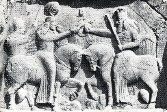 Скальный рельеф (Накши-Рустам) Сасанидский царь Аодашир I (слева) получает венец царской власти от Ормазда Под копытами его коня - парфянский царь Ардабан V, а конь Ормазда попирает Ахримана
