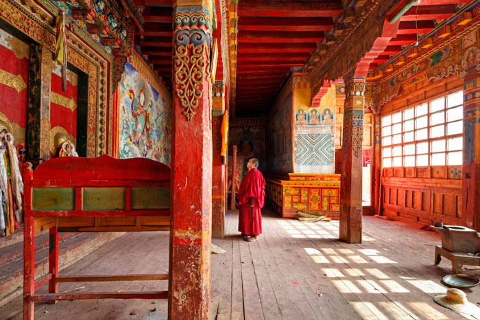 Монах у входа в монастырь Golo Gompa, Сычуань, Китай