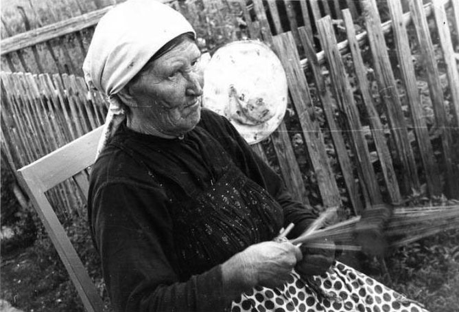 Жена Ивана Тарасьевича за плетением на плашках пояса